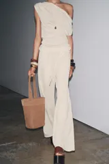 Pantalón de punto color beige, de tiro alto con cintura elástica ajustable con cordones y corte ancho.