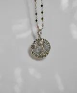Collar con cadena de eslabones plateados y dije redondo con la figura del Espíritu Santo.