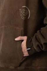 Buzo canguro negro de frisa rústica con corte oversize y capucha. Presenta un pequeño logo blanco en el pecho y un bolsillo tipo canguro.