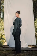 Crewneck (jersey de cuello redondo) unisex color gris oscuro, con estampado frontal que dice "RE:SKIN" y texto pequeño debajo. Presenta mangas largas y corte holgado.