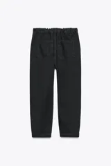 Pantalón de jean negro con efecto lavado, tiro alto, corte carrot fit, cintura elástica en la parte trasera, bolsillos delanteros y traseros, cierre frontal con cremallera y botón metálico.