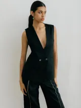 Chaleco sastrero color crema de lino, con cuello en V profundo y cierre cruzado con botón.