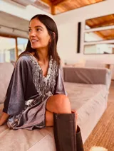 Vestido corto gris de terciopelo con escote en V y flecos de lentejuelas plateadas.