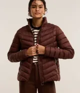 Campera puffer ultraligera color marrón, confeccionada en poliamida acolchada, con cuello alto y cierre por cremallera. Incluye bolsita con cordón.
