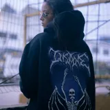 Canguro negro de algodón con capucha ajustable y corte oversize. Estampa blanca con diseño de calavera en el pecho.
