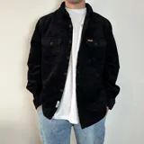 Sobrecamisa color crema de pana con cuello clásico, cierre frontal con botones negros, dos bolsillos de parche en el pecho con solapa abotonada y puños abotonados.