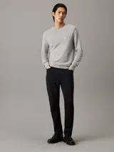 Sweater gris de algodón orgánico con cuello redondo, puños y dobladillo con punto canalé y micro logo de Calvin Klein.