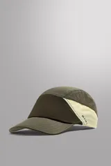 Gorra verde oliva de siete paneles de tejido técnico con perforaciones, visera curva y ajuste elástico en la parte posterior.