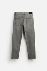 Pantalón de jean azul oscuro, corte slim fit, tiro medio, cinco bolsillos, tejido elástico y efecto lavado.