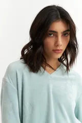 Remera color beige de plush con escote en V y mangas largas.