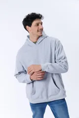 Canguro deportivo gris melange de corte oversize con capucha y bolsillo tipo canguro.