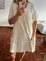 Camisola color crema con botones frontales y detalles de encaje blanco en cuello, mangas y bolsillos.
