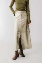 Falda larga de cuero sintético color champagne, corte recto con abertura frontal.