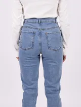 Pantalón jean celeste de corte mom, con tiro alto y bolsillos delanteros y traseros.