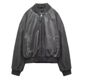 Campera bomber negra de cuero sintético con cuello, puños y ruedo acanalados. Tiene cierre frontal con cremallera, bolsillos laterales con solapa y corte holgado.