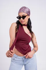 Top color borgoña con escote halter asimétrico y tiras finas que se atan al cuello.