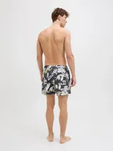 Short de baño con estampado floral en tonos blanco, verde y marrón sobre fondo azul oscuro. Cuenta con cintura elástica, cordón ajustable, bolsillos laterales y trasero.