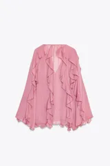 Blusa marrón de gasa con escote en V y manga larga abullonada. Presenta volantes en el mismo tejido y cierre frontal con botones.