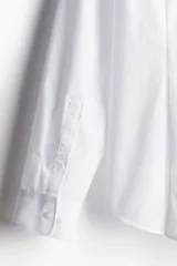 Camisa blanca de corte slim fit, con cuello inglés, tapeta clásica, canesú en la espalda, mangas largas con puños abotonados y bajo levemente redondeado. Confeccionada en tela de fácil planchado.