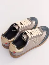 Championes urbanos de cuero color plateado con puntera de gamuza azul y cordones blancos.