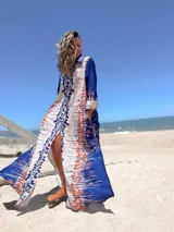 Vestido camisero largo con estampado abstracto en tonos azul, beige y crudo. Tiene cuello camisero, mangas largas y abertura frontal.