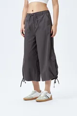 Bermuda gris de corte ancho con bolsillos cargo y tiras ajustables en el ruedo.