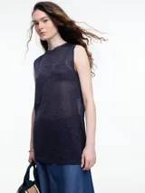 Musculosa sin mangas color gris, tejida en hilado con brillo sutil. De calce relajado y largo por debajo de la cadera, presenta aberturas laterales.