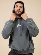 Canguro gris con capucha y cordones ajustables, bolsillo tipo canguro y logo de la marca estampado en el pecho.