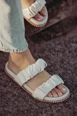 Sandalia de cuero con tiras fruncidas en diseño elegante y cómodo, ideal para el verano.