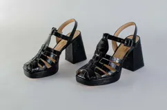 Sandalias negras de cuero con tiras entrecruzadas, plataforma y tacón cuadrado.