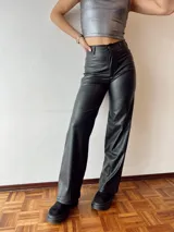 Pantalón de cuero sintético negro, de tiro alto, corte recto y pierna ancha.