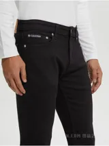 Pantalón de jean negro, corte slim fit, con cierre de botón y cremallera, diseño de cinco bolsillos, herrajes metálicos con logo y parche en la cintura trasera.