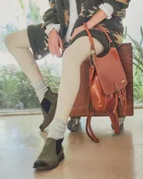 Botines Chelsea de cuero negro con elástico lateral y suela marrón.