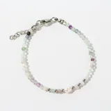 Pulsera de cuentas facetadas de fluorita multicolor con cuentas plateadas y una perla central. Cierre de mosquetón con cadena de alargue.