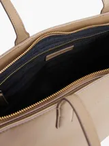 Cartera tote Tommy Hilfiger color beige con sutil acabado granulado. Cuenta con cierre de cremallera, dos asas superiores, compartimento principal, bolsillo interior con cremallera, forro con la inscripción de Tommy Hilfiger y logo de Tommy Hilfiger en la parte delantera.