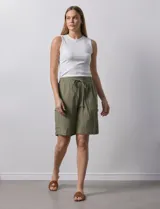 Bermuda de algodón color beige, marca Robert Louis, con pretina ancha elastizada, lazo de ajuste simulado, bolsillos verticales delanteros y bolsillos laterales con botón.