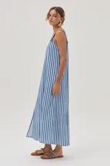 Vestido midi celeste y blanco a rayas verticales, con breteles anchos y corte recto con tajo lateral.