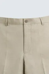 Pantalón de vestir azul marino confeccionado en tejido de lino. Corte recto, con bolsillos laterales y traseros. Se ajusta a la cintura con botón y cremallera.