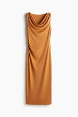 Vestido midi color ocre, sin mangas, de punto elástico con leve brillo. Modelo ajustado con frunces en escote, hombros y en un lateral de la cintura para crear un efecto drapeado.