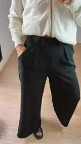 Pantalón de crep elastizado, negro, con pinzas y bolsillos.