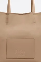 Bolso de mano Bimba y Lola modelo Chihuahua L, color marrón, con doble asa de mano y asa bandolera de tejido. Cierre con botón de presión, logo metálico y acabados plateados.