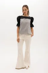 Pantalón de gabardina elastizada color azul marino, de corte acampanado con aberturas laterales con botones.