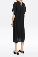 Vestido midi negro de corte recto, con escote en V pronunciado en delantero y espalda, manga corta recta con bajo descosido, cierre frontal con botonadura y fruncidos laterales en el bajo.