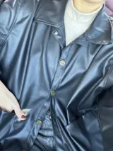 Camisa negra de ecocuero con gamuza interna y botones dorados.