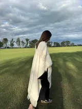 Zapatillas bajas con estampado animal print de vaca en blanco y negro, con cordones marrones y suela color caramelo.