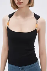Musculosa celeste de punto canale con cuello recto y tirantes anchos decorados con cuentas de madera.