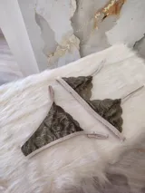 Conjunto de lencería de encaje verde musgo con detalles en beige, compuesto por un corpiño triangular sin aro y una tanga con tiras ajustables.