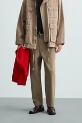 Pantalón verde militar de corte carrot fit, confeccionado en tejido de algodón. Cuenta con cintura elástica ajustable con cordón, bolsillos frontales y un bolsillo trasero de plastrón.
