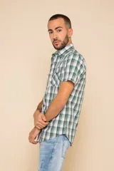 Camisa de manga corta con estampado a cuadros en tonos azul, rojo y blanco. Cierre con botones y tela ligera.