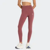 Calza deportiva larga color ladrillo, de tiro alto y calce ajustado, con logo reflectivo de New Balance en la pierna izquierda.